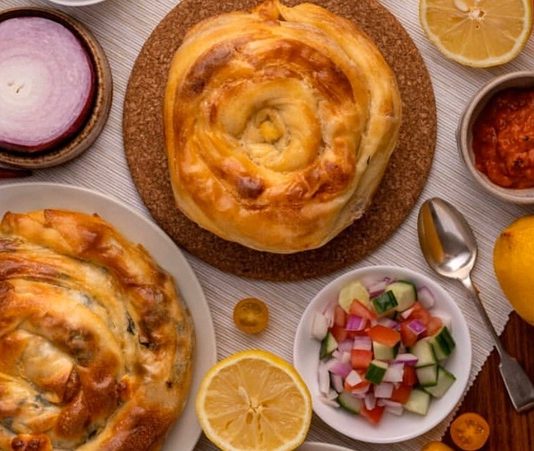 Balkan mutfağı, yüzyıllardır farklı kültürlerin etkileşimiyle şekillenmiş ve bölge halklarının yaşam biçimlerine göre zenginleşmiştir. Osmanlı İmparatorluğu’nun uzun süre bölgede hâkimiyet kurması, mutfak kültürünü derinden etkilemiş, hem yerel hem de Türk yemekleri Balkan sofralarının bir parçası haline gelmiştir. Aynı zamanda Yunan, Slav ve Avusturya-Macaristan etkileri de bu mutfağın çeşitliliğine katkıda bulunmuştur. Bu nedenle Balkan yemekleri hem Doğu hem Batı tatlarını bir araya getiren özel bir sentez niteliğindedir. Başlıklı bir haber görseli.