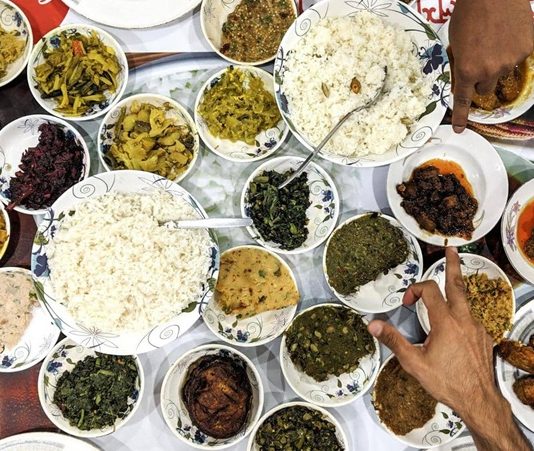 Bangladeş Mutfağı Bangladeş, tarih boyunca farklı kültürlerin etkisi altında kalmış bir coğrafyada yer alır. Bu durum, Bangladeş mutfağının çeşitliliğini ve zenginliğini doğrudan etkilemiştir. Hindistan, Arap ve Asya etkileri, yemek kültüründe kendini gösterir ve mutfağı hem lezzet hem de görsellik açısından zenginleştirir. Baharatların ustaca kullanımı, pirinç ve balık ağırlıklı yemekler ve aromatik soslar, Bangladeş mutfağının karakteristik özelliklerindendir. Konulu bir haber görseli.