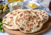 Bazlama: Sıcacık Sofraların Vazgeçilmez Ekmeği Bazlama, Türk mutfağının en eski ve en bilinen ekmeklerinden biridir. Tarihi, Osmanlı dönemi ve öncesine kadar uzanır. Özellikle köylerde ve taş fırınlarda yapılan bazlama, sabah kahvaltılarının ve yemeklerin vazgeçilmez bir parçası olmuştur. Hamurun mayalanması ve sac üzerinde pişirilmesi, ona kendine özgü yumuşak ve hafif kabarık dokusunu kazandırır. Konulu bir haber görseli.