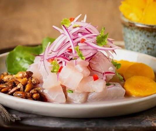 Ceviche, özellikle Güney Amerika mutfağının ikonik tariflerinden biridir ve taze balık veya deniz ürünlerinin asidik sıvılarla marine edilerek pişirilmeden servis edilmesi esasına dayanır. Ceviche, taze ve aromatik bir lezzet sunar ve yemeklerde hafif ama etkileyici bir tat deneyimi yaratır. Konulu bir haber görseli.