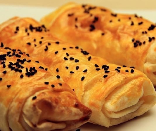 El Açması Hamur İşleri Gelenekten Sofraya Uzanan Sıcacık Lezzetler El açması hamur işleri, Türk mutfağının en sevilen ve en çok sahip çıkılan lezzetlerinden biridir. Anadolu’nun dört bir yanında nesiller boyu aktarılan bu geleneksel tarifler, özellikle ev hanımlarının maharetli elleriyle sofralara taşınır. Yufkanın incecik açıldığı, iç harcının özenle hazırlandığı bu tarifler, yalnızca bir yemek değil, aynı zamanda bir kültürel hafıza görevi de görür. Konulu bir haber görseli.