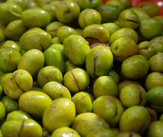 Yeşil Zeytin: Sofralarda Sağlık ve Lezzet Bir Arada Akdeniz’in bereketli topraklarında yetişen yeşil zeytin, binlerce yıllık bir geçmişe sahip. Tarih boyunca birçok uygarlık için hem besin kaynağı hem de kültürel bir sembol olmuştur. Antik dönemlerde kutsal sayılan zeytin ağacı, barışın ve bolluğun işareti olarak görülmüş, sofralara sunduğu yeşil zeytin ile insanlığın yaşamına değer katmıştır. Konulu bir haber görseli.