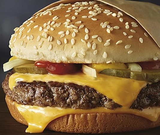 Cheeseburger, adını aldığı peynirle birleşerek hamburgerin en sevilen versiyonlarından biri olmuştur. İlk olarak 1920’lerde Amerika’da ortaya çıktığı bilinen cheeseburger, kısa sürede tüm dünyaya yayılarak milyonların vazgeçilmez lezzeti haline gelmiştir. Hamburgerin köfte ve ekmekten oluşan temel yapısına eriyen peynirin eklenmesiyle doğan bu tarif, damakta farklı bir tat yaratmıştır. Konulu bir haber görseli.
