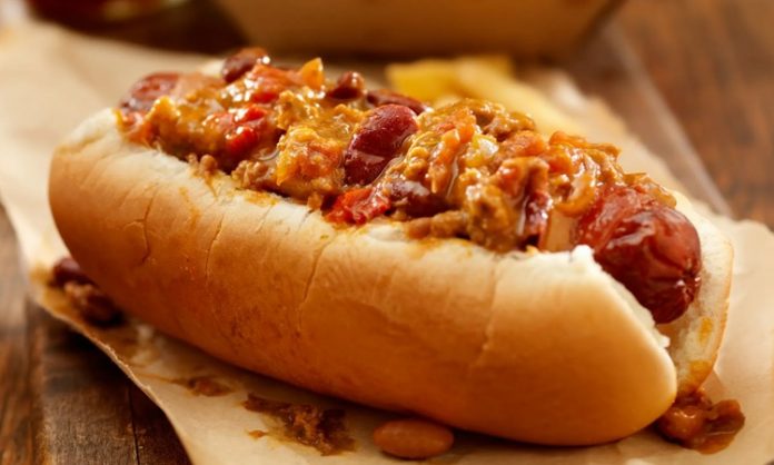 Chili Dog Sokak Lezzetlerinin Baharatlı Yıldızı Amerika mutfağının en sevilen sokak lezzetlerinden biri olan chili dog, klasik hot dog’un baharatlı bir versiyonudur. Kökeni 20. yüzyılın başlarına uzanan bu yiyecek, özellikle Teksas ve Kaliforniya sokaklarında popüler hale gelmiştir. Klasik sosis ve ekmek kombinasyonunun üzerine eklenen acılı chili sos, chili dog’un karakteristik özelliğini oluşturur. Konulu bir haber görseli.