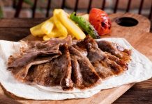 Et Döner: Lezzetiyle Türk Mutfağının Vazgeçilmez Lezzeti Türk mutfağının en önemli lezzetlerinden biri olan et döner, tarihsel olarak Osmanlı döneminden günümüze kadar uzanan bir yolculuğa sahiptir. Yatay şişlerde pişirilen etlerin zamanla dikey şişlere geçirilmesiyle ortaya çıkan bu yöntem, özellikle hızlı servis imkânı ve eşsiz lezzetiyle kısa sürede halkın gözdesi haline gelmiştir. Dönerin geçmişi, yalnızca bir yemeğin tarihi değil, aynı zamanda Anadolu’nun kültürel çeşitliliğinin de bir yansımasıdır. Konulu bir haber görseli.
