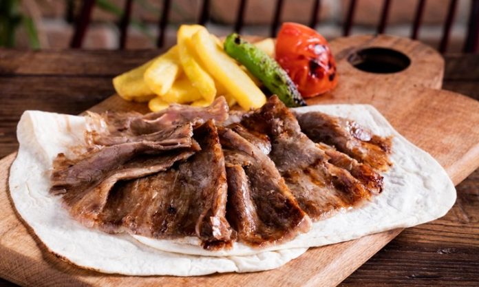 Türk mutfağının en önemli lezzetlerinden biri olan et döner, tarihsel olarak Osmanlı döneminden günümüze kadar uzanan bir yolculuğa sahiptir. Yatay şişlerde pişirilen etlerin zamanla dikey şişlere geçirilmesiyle ortaya çıkan bu yöntem, özellikle hızlı servis imkânı ve eşsiz lezzetiyle kısa sürede halkın gözdesi haline gelmiştir. Dönerin geçmişi, yalnızca bir yemeğin tarihi değil, aynı zamanda Anadolu’nun kültürel çeşitliliğinin de bir yansımasıdır. Konulu bir haber görseli.