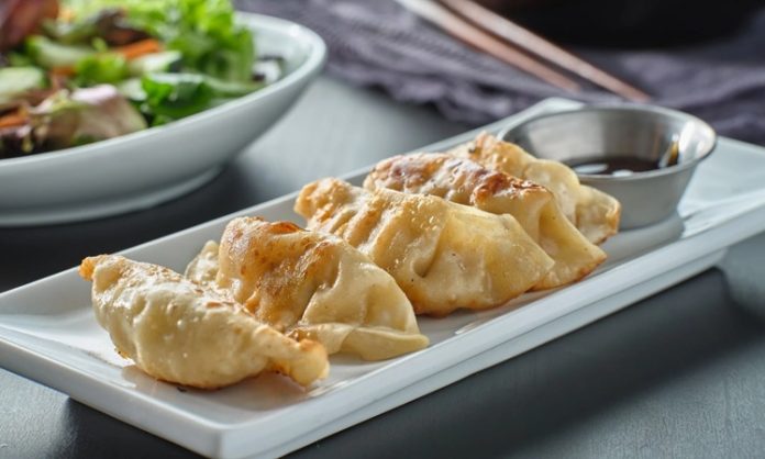 Gyoza, Japon mutfağının en sevilen yemeklerinden biridir ve kökeni Çin’e dayanmaktadır. Aslında Çin’deki jiaozi adı verilen hamur işinden esinlenerek Japonya’ya taşınmış ve zamanla farklı bir kimlik kazanmıştır. Japon mutfağına özgü pişirme teknikleri, gyozayı benzersiz bir hale getirmiştir. Bugün hem Japonya’da hem de dünyanın birçok ülkesinde gyoza, restoranların ve ev sofralarının vazgeçilmez lezzetleri arasında yer almaktadır. Konulu bir haber görseli.