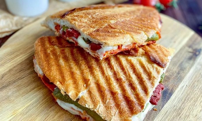 Karışık Tost Kahvaltıdan Öğleye Pratik Lezzet Karışık tost, özellikle Türkiye’de sabah kahvaltılarının ve ara öğünlerin vazgeçilmez lezzetlerinden biri haline gelmiştir. Bu tost çeşidi, klasik kaşarlı tostun ötesine geçerek sucuk, salam, domates, biber ve peynir gibi malzemelerin bir araya gelmesiyle hazırlanır. Böylece hem doyurucu hem de zengin bir lezzet sunar. Konulu bir haber görseli.