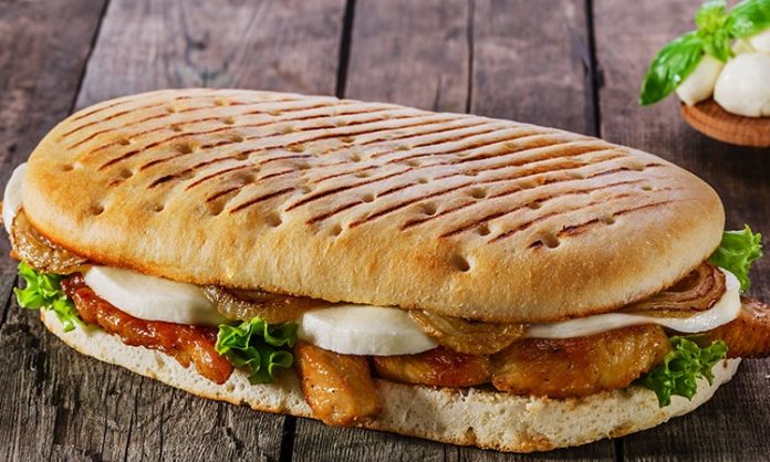 Panini İtalyan Lezzetinin Hızlı Atıştırması Panini, İtalyan mutfağının en sevilen ve hızlı atıştırmalık seçeneklerinden biridir. Kelime anlamı olarak “küçük ekmekler” anlamına gelen panini, İtalya’da özellikle öğle yemeklerinde tercih edilir. Geleneksel olarak ciabatta veya focaccia ekmeği kullanılarak hazırlanan panini, peynir, et ve sebzelerle zenginleştirilir. Konulu bir haber görseli.