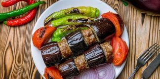 Patlıcan Kebabı: Sofraların Lezzetli ve Geleneksel Yemeği Türk mutfağının vazgeçilmez lezzetlerinden biri olan patlıcan kebabı, özellikle Gaziantep, Şanlıurfa ve Adana gibi şehirlerde sıkça hazırlanır. Patlıcanın közlenip etle buluşmasıyla ortaya çıkan bu yemek, hem hafif hem de doyurucu bir öğün sunar. Osmanlı mutfağından günümüze uzanan tarif, yöresel farklılıklarla her sofrada kendine özgü bir tat bırakır. Konulu bir haber görseli.
