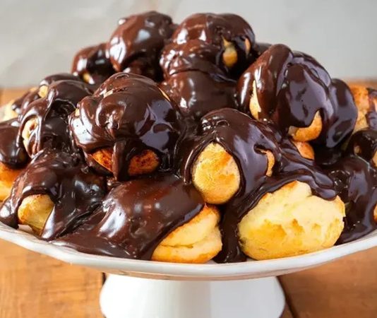 Profiterol: Küçük Tatlıların Büyük Keyfi Profiterol, Fransız mutfağından çıkmış, ince ve hafif hamurun içine krem doldurularak yapılan bir tatlıdır. İlk olarak 16. yüzyılda Fransa’da ortaya çıkan bu lezzet, kısa sürede Avrupa’nın farklı bölgelerine yayılmıştır. Hafif yapısı ve şık sunumuyla profiterol, özel günler ve davet sofralarının vazgeçilmezi haline gelmiştir. Konulu bir haber görseli.