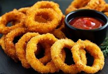 Soğan halkası, fast food kültürünün en sevilen atıştırmalıklarından biri olarak öne çıkıyor. Tarihi 20. yüzyılın ortalarına dayanan bu lezzet, özellikle Amerika’da popülerlik kazanmış ve kısa sürede dünya mutfaklarına yayılmıştır. Patates kızartmaları ve burgerlerin yanında ikincil lezzet olarak sunulan soğan halkaları, hem çıtır dokusu hem de tatlımsı soğan aroması ile dikkat çekiyor. Konulu bir haber görseli.