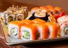 Sushi roll, Japon mutfağının en bilinen yemeklerinden biridir ve dünya genelinde ün kazanmıştır. İlk olarak Edo döneminde ortaya çıkan sushi, başlangıçta balığın pirinç içinde fermente edilmesiyle hazırlanıyordu. Zaman içinde bu yöntem değişti ve daha modern bir hale geldi. Özellikle 20. yüzyılın ortalarında Amerika’da popülerleşen sushi roll, farklı malzemelerin bir araya gelmesiyle çeşitlenerek bugünkü halini aldı. Konulu bir haber görseli.
