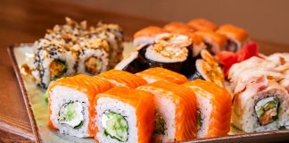 Sushi roll, Japon mutfağının en bilinen yemeklerinden biridir ve dünya genelinde ün kazanmıştır. İlk olarak Edo döneminde ortaya çıkan sushi, başlangıçta balığın pirinç içinde fermente edilmesiyle hazırlanıyordu. Zaman içinde bu yöntem değişti ve daha modern bir hale geldi. Özellikle 20. yüzyılın ortalarında Amerika’da popülerleşen sushi roll, farklı malzemelerin bir araya gelmesiyle çeşitlenerek bugünkü halini aldı. Konulu bir haber görseli.
