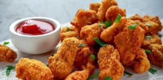 Tavuk nugget, hem çocuklar hem de yetişkinler tarafından çok sevilen bir atıştırmalıktır. Altın rengi çıtır kaplaması ve yumuşak tavuk eti ile mükemmel bir uyum sağlayan nugget, evde veya restoranlarda kolayca hazırlanabilir. Özellikle hızlı atıştırmalık olarak tercih edilen bu lezzet, farklı soslar ile birlikte sunulduğunda sofralara renk katar. Bugün tavuk nugget’in tarihçesinden hazırlama tekniklerine, pişirme yöntemlerinden sunum önerilerine kadar detaylı bir inceleme yapacağız. Konulu bir haber görseli.