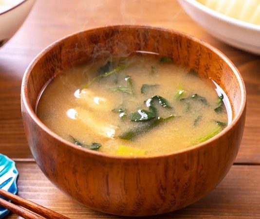 Miso Çorbasının Sırrı Ve Sağlık Üzerindeki Etkileri Miso, Japon mutfağının vazgeçilmez lezzetlerinden biridir ve son yıllarda dünya genelinde sağlıklı beslenme trendleri arasında önemli bir yer kazanmıştır. Miso, fermente edilmiş soya fasulyesi ve tuzdan elde edilen geleneksel bir Japon gıdasıdır. Sade görünmesine rağmen, içerdiği zengin besin değerleri sayesinde hem lezzet hem de sağlık açısından büyük faydalar sunar. Japon kültüründe günlük beslenmenin ayrılmaz bir parçası olan miso, çorba, sos ve hatta bazı tatlı tariflerinde bile kullanılmaktadır. Konulu bir haber görseli.