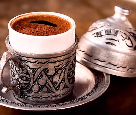 Kahve Kültürü Ve Dünya Sofralarında Lezzet Ruhu Kahve, yüzyıllardır hem yemek kültürü hem de sosyal yaşamın önemli bir parçası olmuştur. Etiyopya kökenli kahve, zamanla Osmanlı topraklarından Avrupa’ya ve tüm dünyaya yayılmıştır. Kahvenin keşfi, sadece bir içecek olarak değil, kültürel bir ritüel ve toplumsal bir gelenek olarak da değer kazanmasını sağlamıştır. Kahve kültürü, sohbetlerin, misafir ağırlamanın ve sosyal etkileşimlerin merkezinde yer almıştır. Konulu bir haber görseli.