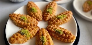 Türk mutfağı tatlı denildiğinde benzersiz bir mirasa sahiptir. Bu mirasın içinde bazı tatlılar vardır ki yıllar geçse de hem görünümü hem tadı aynı ilgiyle karşılanır. İşte kalburabastı tam da böyle tatlılardan biridir. Osmanlıdan günümüze uzanan bu özel tarif, özellikle bayram sofralarında ve özel günlerde en çok tercih edilen şerbetli tatlıların başında geliyor. Son yıllarda geleneksel tatlılara dönüş hareketinin artmasıyla birlikte kalburabastı yeniden gündemde. Özellikle ev yapımı tarifler sosyal medyada sık sık karşımıza çıkarken genç kuşaklar bu tatlıyı yeniden keşfetmeye başladı. Konulu bir haber görseli.