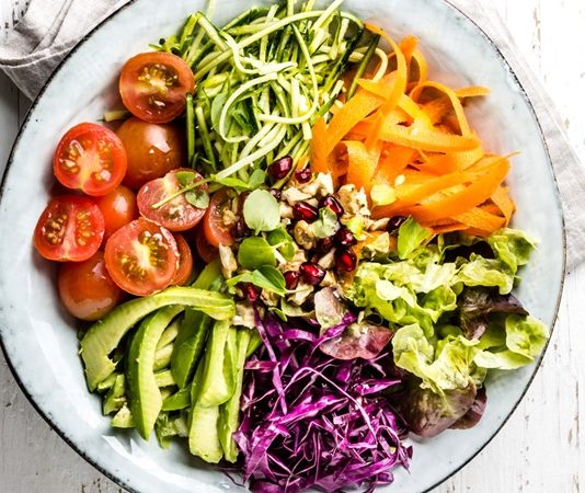 Raw Vegan Beslenme Doğal Yaşam Arayışında Öne Çıkıyor Raw vegan beslenme, son yıllarda doğal yaşam ve bilinçli beslenme arayışında olan bireylerin dikkatini çeken özel bir beslenme yaklaşımı olarak öne çıkmaktadır. Bu beslenme biçimi, hem vegan felsefeyi hem de gıdaların işlenmeden tüketilmesini esas almasıyla klasik bitkisel beslenmeden ayrılmaktadır. Raw Vegan Beslenme, modern yaşamın getirdiği yoğun işlenmiş gıda tüketimine karşı bir tepki niteliği taşımaktadır. Konulu bir haber görseli.