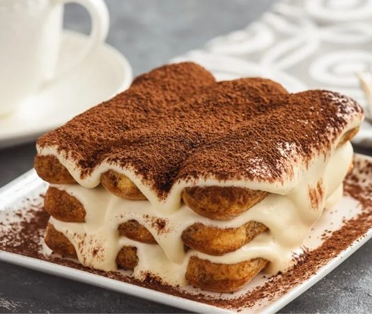 Tiramisu Lezzet Yolculuğunda İtalya’dan Dünyaya Uzanan Tatlı Bir Hikâye İtalyan mutfağının dünya çapında en bilinen tatlılarından biri olan tiramisu, sadece hafifliğiyle değil içinde barındırdığı zengin aromalarla da her yaştan insanın damak zevkine hitap etmeyi başarıyor. İlk bakışta yumuşak yapısı ile dikkat çeken tiramisu, kahve aromalı bisküvileri ve mascarpone kreması sayesinde kendine özgü bir tat profili oluşturuyor. Bugün birçok pastane ve restoran menüsünde yer alan tiramisu, hem geçmişten gelen kültürel özellikleri hem de modern yorumlarıyla öne çıkmayı sürdürüyor. Konulu bir haber görseli.