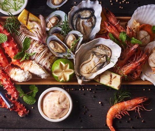 Balık restoranları, deniz kültürünün sofraya yansıyan en canlı örneklerinden biri olarak Türkiye’de hem geleneksel hem de modern anlayışla varlığını sürdürüyor. Kıyı şehirlerinden iç bölgelere kadar uzanan bu lezzet hattı, yalnızca yemek yenen mekânlar olmanın ötesinde bir yaşam tarzını ve sosyal buluşma kültürünü temsil ediyor. Günümüzde balık restoranları, taze ürün kullanımı, mevsimsellik ve sunum anlayışıyla gastronomi dünyasında ayrı bir konuma yerleşmiş durumda. Konulu bir haber görseli.