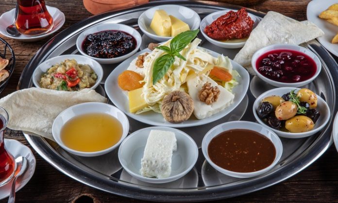 Doğallığın Ve Lezzetin Buluştuğu Köy Kahvaltısı Mekanları Şehir hayatının yoğun temposundan uzaklaşmak isteyenlerin son yıllarda en çok tercih ettiği gastronomi duraklarından biri köy kahvaltısı mekanları oluyor. Doğal ürünlerle hazırlanan sofralar, sakin ortamlar ve geleneksel tatlar, bu mekanları yalnızca bir kahvaltı noktası değil, aynı zamanda bir deneyim alanı haline getiriyor. Özellikle hafta sonları ailelerin ve arkadaş gruplarının yoğun ilgi gösterdiği köy kahvaltısı mekanları, doğayla iç içe vakit geçirmek isteyenler için güçlü bir alternatif sunuyor. Konulu bir haber görseli.