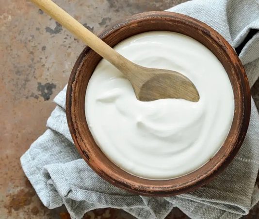 Yoğurt Sağlıklı Beslenmenin Vazgeçilmez Lezzeti Olmayı Sürdürüyor Geleneksel mutfağın en köklü ürünlerinden biri olan yoğurt, hem lezzeti hem de sağlığa olan katkılarıyla sofralardaki yerini korumaya devam ediyor. Yüzyıllardır tüketilen bu fermente süt ürünü, modern beslenme trendleriyle birlikte yeniden yükselişe geçmiş durumda. Artan sağlık bilinci, doğal ürünlere yönelim ve probiyotik besinlere olan ilgi, yoğurt tüketimini son yıllarda belirgin biçimde artırdı. Konulu bir haber görseli.